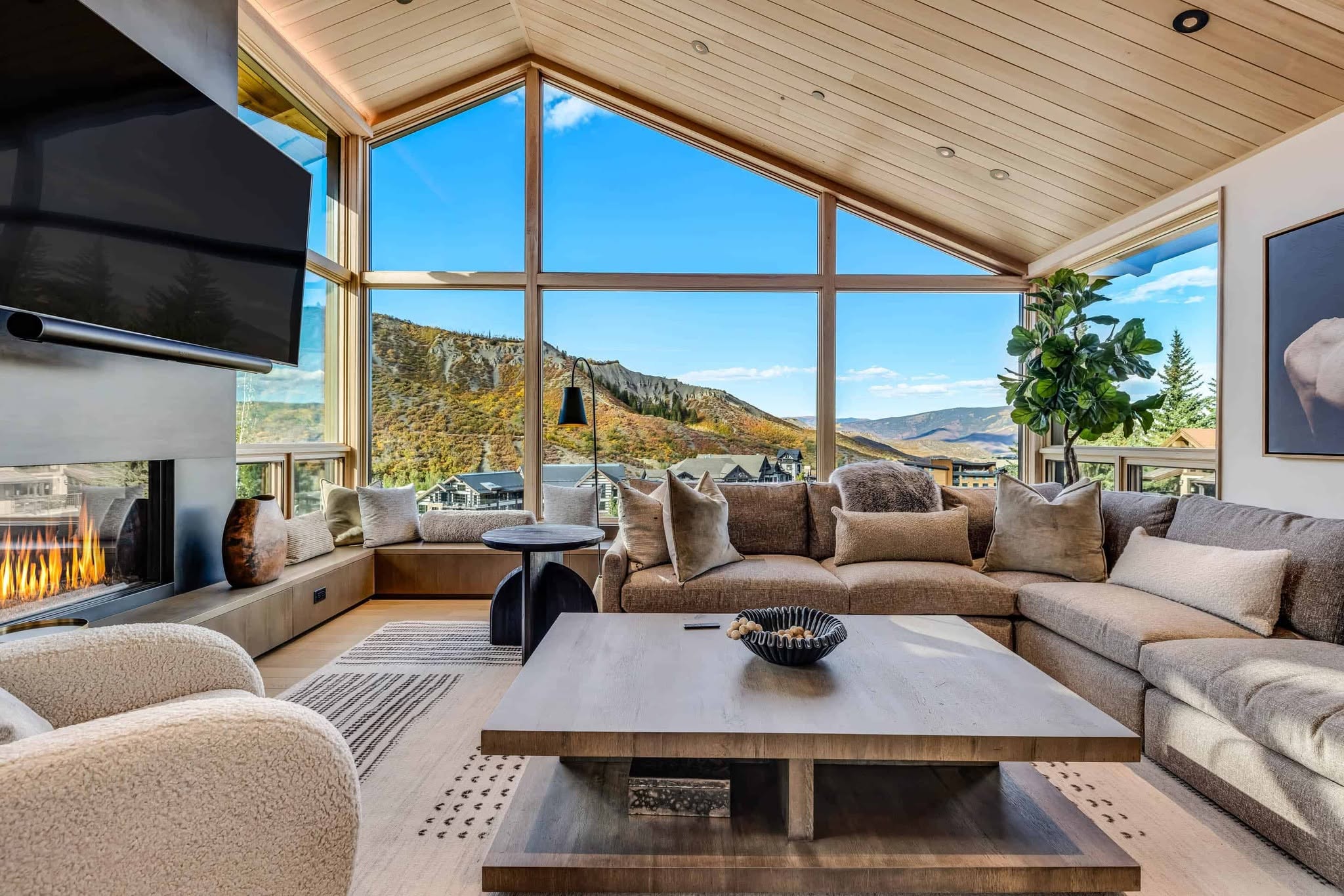 Cozy living room featuring a large window and a warm fireplace, inviting natural light and comfort.
