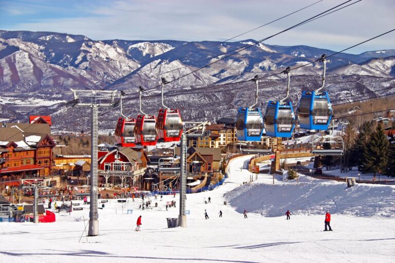 A group of skiers enjoying a ride on a ski lift, with a scenic winter landscape in the background.